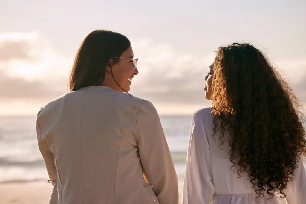 Two women talking on beach