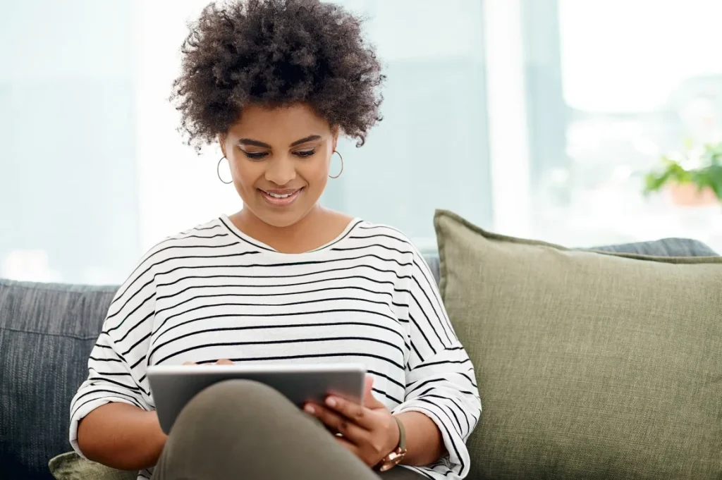 Woman smiling using iPad to contact Nurture and Navigate